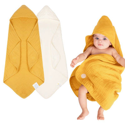 Baby wrapped in a hooded muslin cotton bath towel designed for gentle drying after bath time. The soft, breathable fabric keeps baby warm and comfortable while the hood helps dry the head quickly. Large absorbent towel designed to wrap newborns and infants securely for cozy post-bath care.