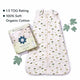 Nintara Baby sleep sack laid flat beside its gift box packaging. Text highlights 1.5 TOG rating and 100% soft organic cotton. Decorative green leaves styled around the product on a white surface.