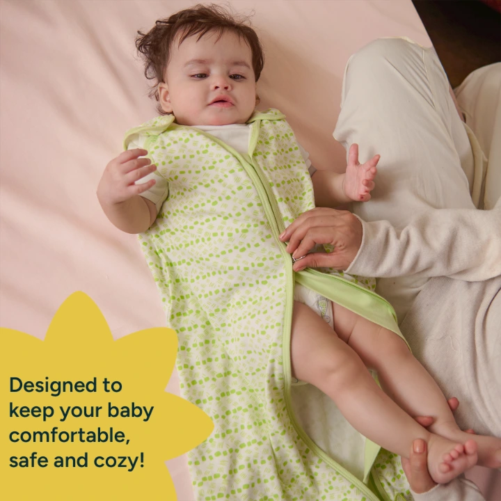A parent unzips a Nintara Baby sleep sack from the bottom for a diaper change while baby lies on a soft surface with legs raised.A parent unzips a Nintara Baby sleep sack from the bottom for a diaper change while baby lies on a soft surface with legs raised. Text reads: Designed to keep your baby comfortable, safe and cozy.