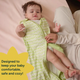 A parent unzips a Nintara Baby sleep sack from the bottom for a diaper change while baby lies on a soft surface with legs raised.A parent unzips a Nintara Baby sleep sack from the bottom for a diaper change while baby lies on a soft surface with legs raised. Text reads: Designed to keep your baby comfortable, safe and cozy.