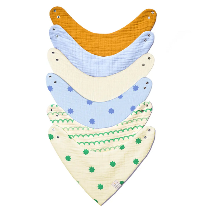 Stack of six patterned and solid-colored Baby Bandana Bibs with snap closures in Fresh Bloom Mega Pack
