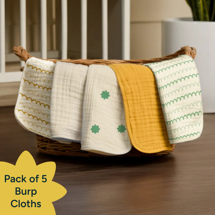 Basket with pack of 5 burp cloths on a wooden surface