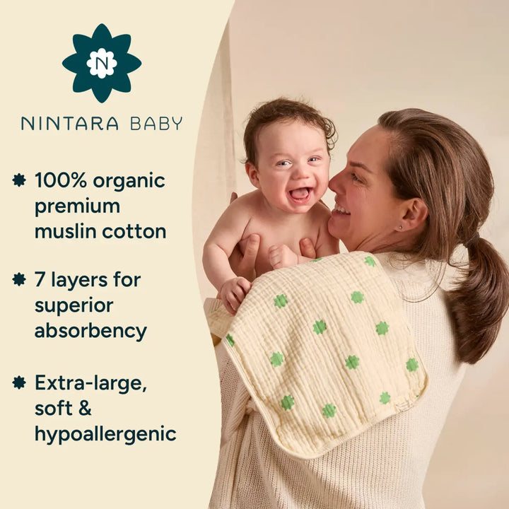 Graphic titled "Nintara Baby Highlights- showcasing the brand's premium baby essentials. On the left side, the text emphasizes three key product features: "100% organic premium muslin cotton,- "7 layers for superior absorbency,- and "Extra-large, soft & hypoallergenic,- each marked with a small floral icon. On the right side, a smiling mother holds a laughing baby wrapped in a cream-colored muslin cloth with green floral prints.