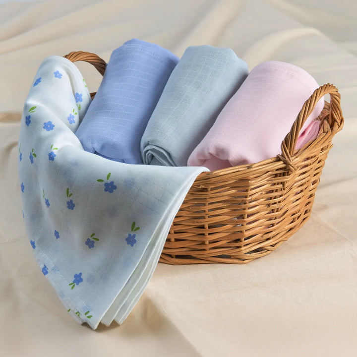 Woven wicker basket with pastel baby blankets including a blue floral swaddle set