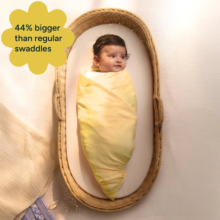 A close-up of a baby wrapped in a soft yellow swaddle made from organic cotton. The image emphasizes the softness of the swaddle while highlighting the extra-large size (47” x 47”) that provides more space for the baby to grow into. The 100% organic cotton material is gentle on the baby’s skin, offering superior comfort compared to regular cotton-blend swaddles.