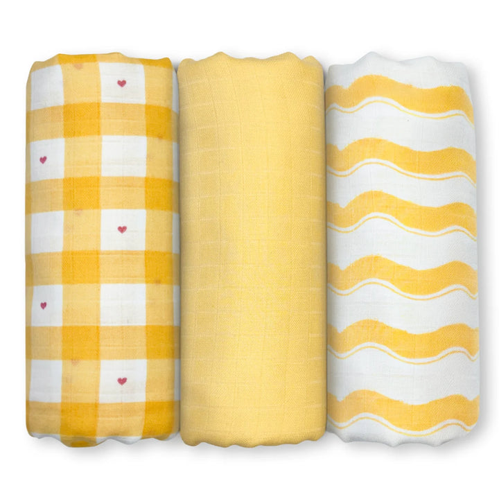 Three rolled baby swaddles in yellow and white patterns for Sunshine Baby product